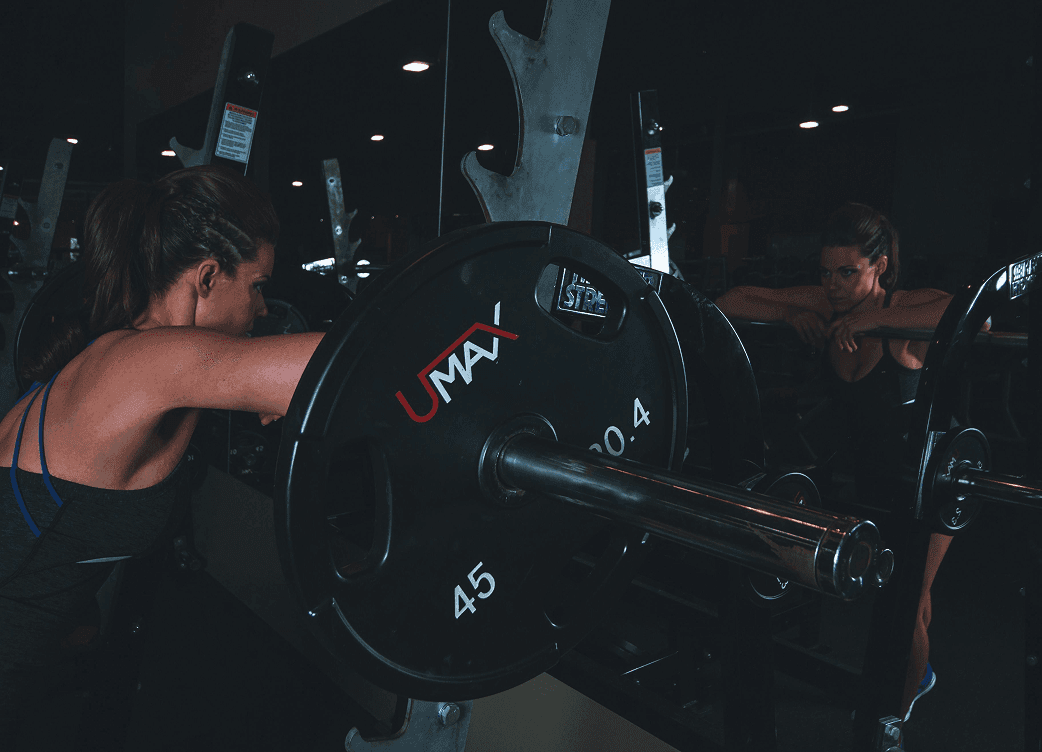 Phone propped up on a gym bench recording a lifting set